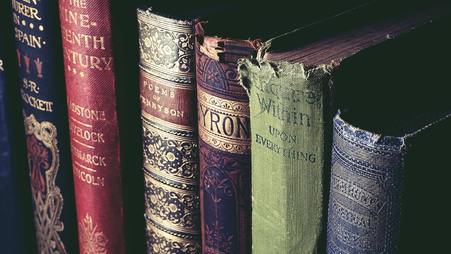 Six antique books on a shelf