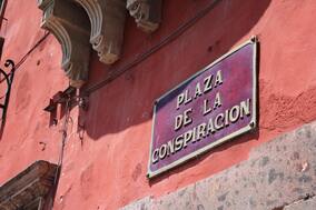 Street sign on pink stucco building for Plaza de la Conspiracion in San Miguel de Allende, Mexico