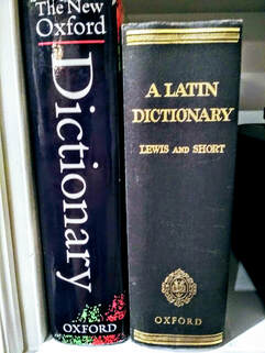 The New Oxford English Dictionary and Lewis and Short's A Latin Dictionary standing vertically on a white shelf
