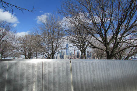 American Immigrant Wall of Honor on Ellis Island with view of New York City behind it