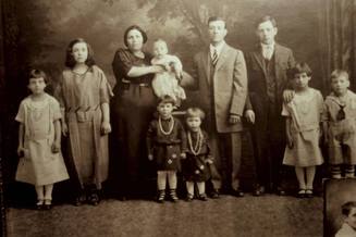 Formal black and white portrait of an Italian family ca. 1925, mother and father and eight children ranging in age from 17 to infant